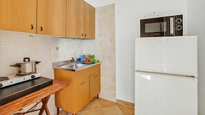 Eine Küche mit Holzausstattung, einem Herd, einer Spüle und einem weißen Kühlschrank.