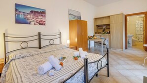 Ein Hotelzimmer mit Bett, Schreibtisch, Küchenzeile und Bad.