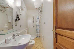 Een douche, een haardroger, een bidet, handdoeken