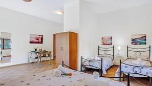 Een hotelkamer met twee bedden, een zithoek en een kleine tafel met stoelen.