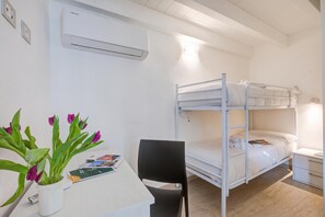 A bunk bed room with a desk, chair, and a potted plant. - Peschiera Lake View + Parking, Peschiera del Garda, Italy (Peschiera del Garda)