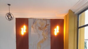 A reception desk with a marble design, two wall-mounted lights, and a large window with a view. - Casa de royal guest house (Kasoa)