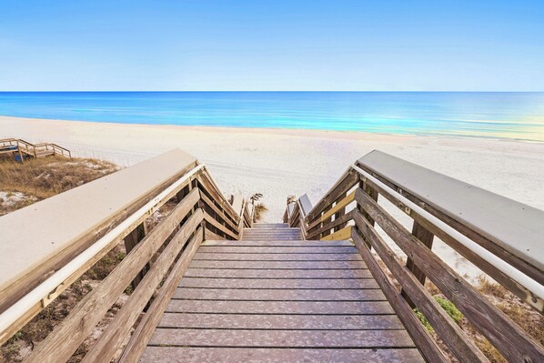 A wooden staircase leading to a beach with a clear view of the ocean. - Sage & Sand: Golf Cart, Bikes & Pickleball (Santa Rosa Beach)