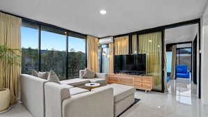 Un soggiorno moderno con un divano componibile, una televisione e un mobile in legno.