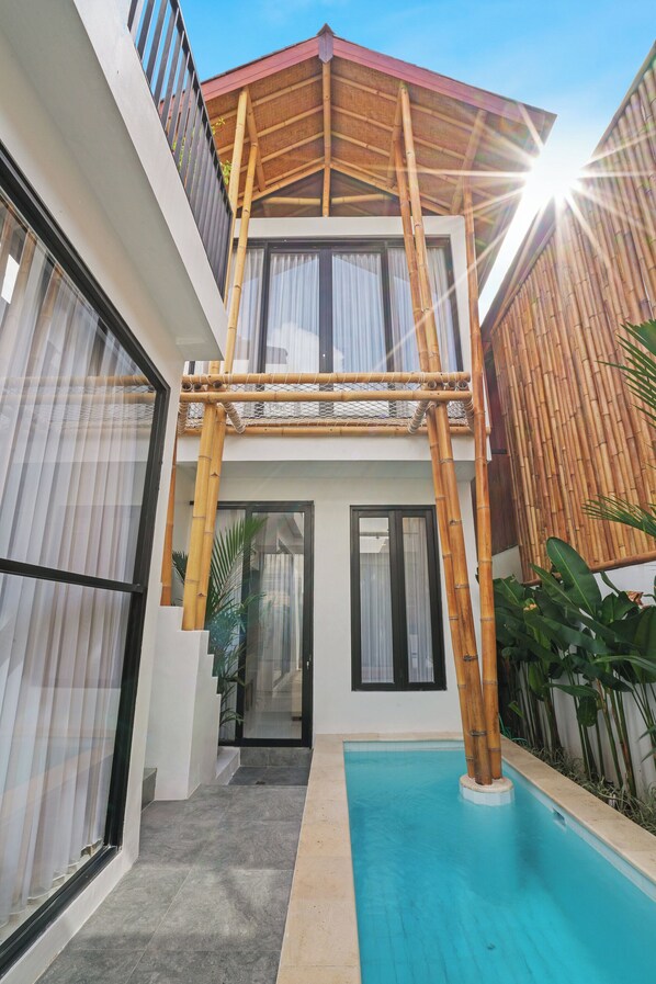 A modern building with a pool, large windows, and a covered outdoor area. - Lux Villages and K Hotel (Keroboken Kelod)