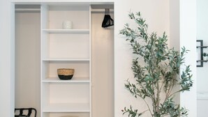 A white shelving unit with a woven basket and a decorative item on one shelf. - Charming 3-bedroom house in peaceful Tempe minutes from the Aiport (Tempe)