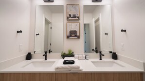 A modern bathroom with two sinks, a large mirror, and a small potted plant. - Modern Townhome 10 min to Downtown + Airport (Salt Lake City)
