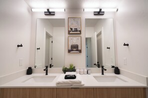 A modern bathroom with two sinks, a large mirror, and a small potted plant. - Modern Townhome 10 min to Downtown + Airport (Salt Lake City)