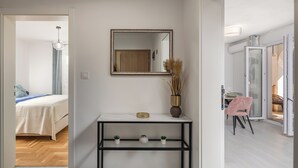 Een hotelkamer met een bed, een console tafel, een spiegel en uitzicht op het balkon.