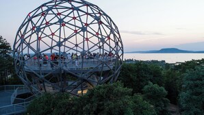A geodesic dome structure with multiple levels and a viewing platform, surrounded by dense greenery. - Studio with air conditioning and Wi-Fi near the water (Balatonlelle)