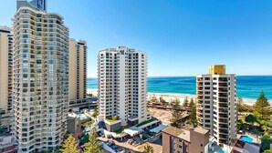 Ein Hochhaus-Hotel mit mehreren Etagen, Blick auf den Strand und einem Poolbereich.