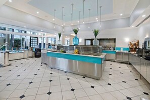 A modern kitchen with a central island, stainless steel appliances, and a tiled floor. - Legends Hotel - Private Apartments Hosted by Coastal Letting Co (Surfers Paradise)