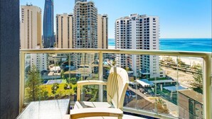 Ein Balkon mit Blick auf hohe Gebäude und das Meer.