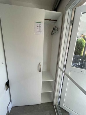 A narrow hallway with a door leading to a room, a coat rack, and a window with a view of greenery outside. - Studio near the water with large terrace, air conditioning and Wi-Fi (Balatonlelle)