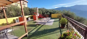 A rooftop terrace with outdoor furniture, a pergola, and a view of mountains. - Holiday flat with magical terrace (Lucinasco)