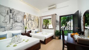 Une chambre d’hôtel avec deux lits, un bureau et un grand tableau abstrait accroché au mur.