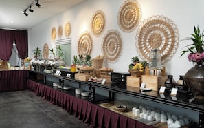 Un buffet proposant une variété de plats et agrémenté d’œuvres d’art décoratives murales.