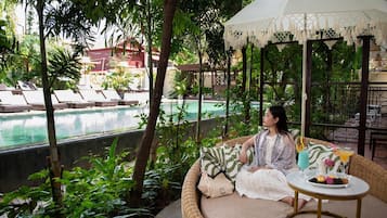 Una piscina al aire libre, sillones reclinables de piscina