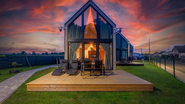 Uma casa moderna com varanda, área de estar externa e vista do céu.