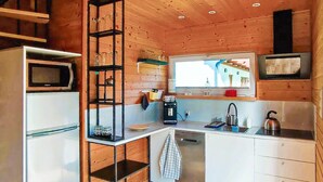 Un angolo cottura compatto con forno a microonde, macchina del caffè e una finestra vista.