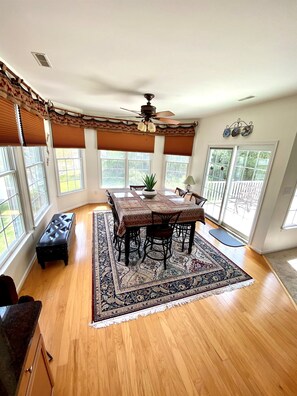 A dining area with a table, chairs, a ceiling fan, and large windows. - Spacious Luxury Home in Waterfront Resort w/ Pools (Berlin)