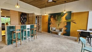 A modern interior with a bar area, seating, and a large plant. - Vhora Resort (Cajidiocan)
