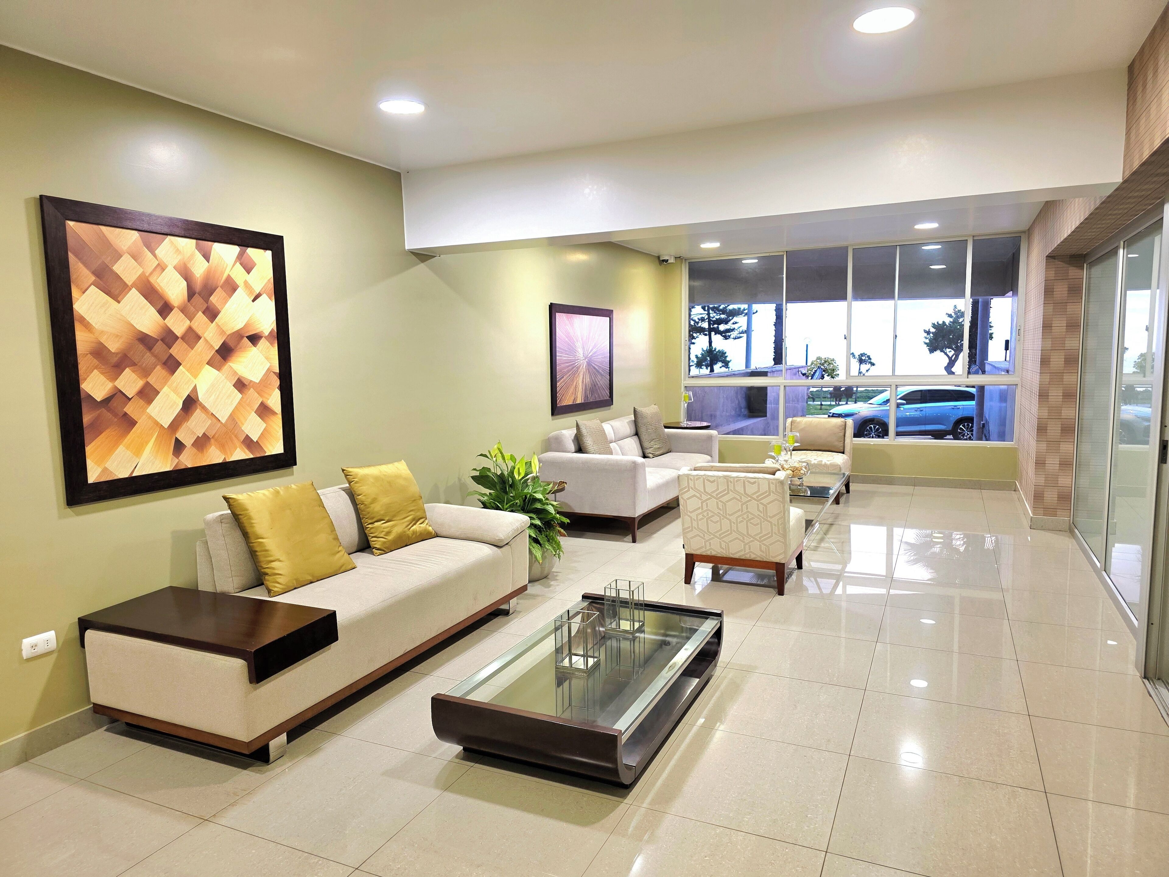 A modern lobby with a sofa, armchairs, a coffee table, and artwork on the walls.