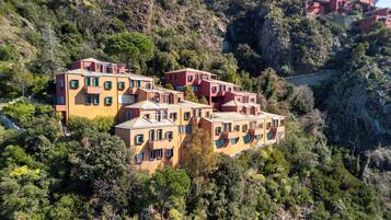 Una proprietà collinare con diversi edifici, una scala e un terreno roccioso.