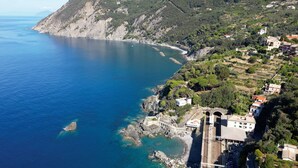 Una cittadina costiera con una linea ferroviaria, un litorale roccioso e edifici.