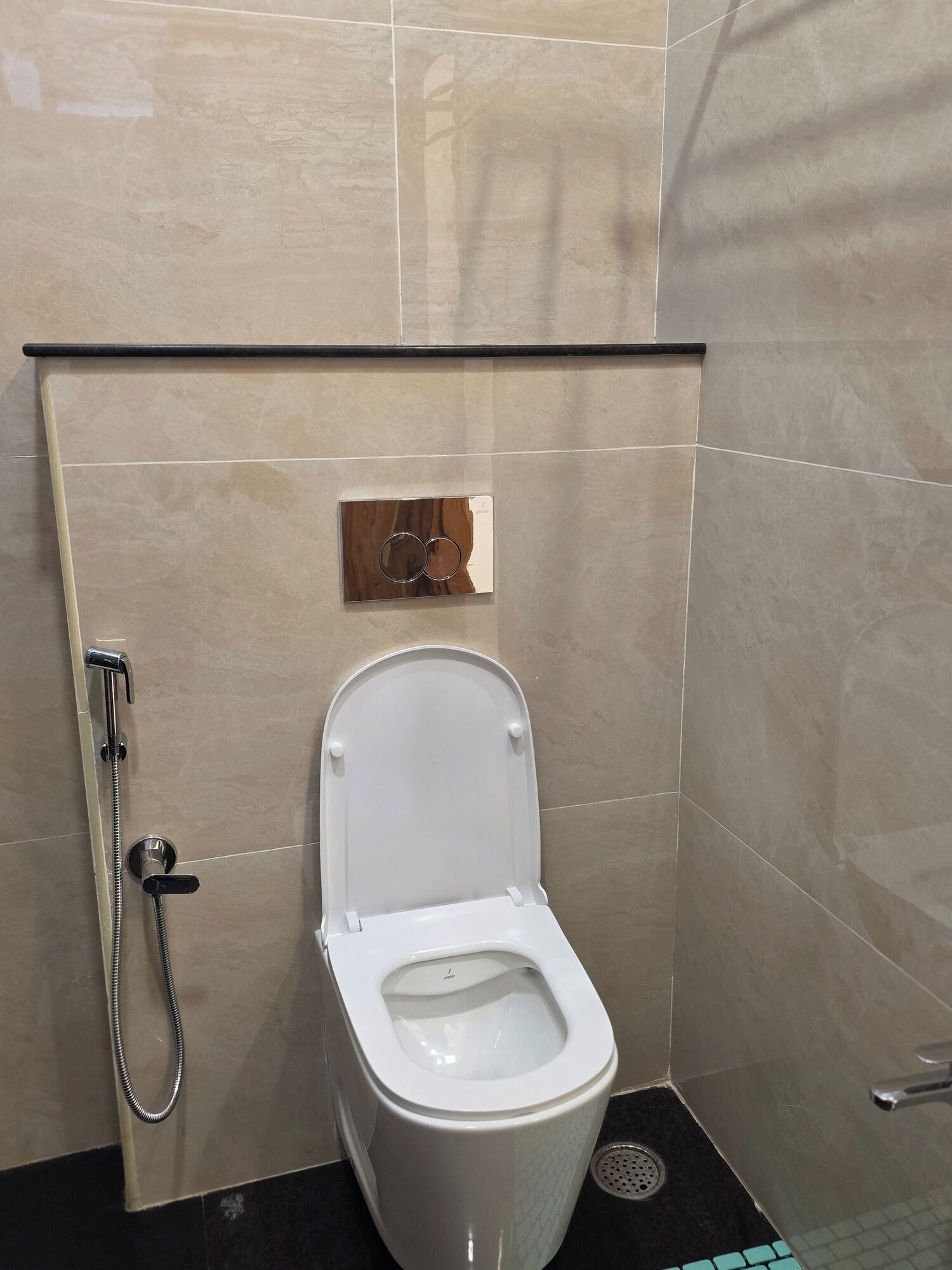 A modern bathroom with a toilet, a shower, and a hand dryer.