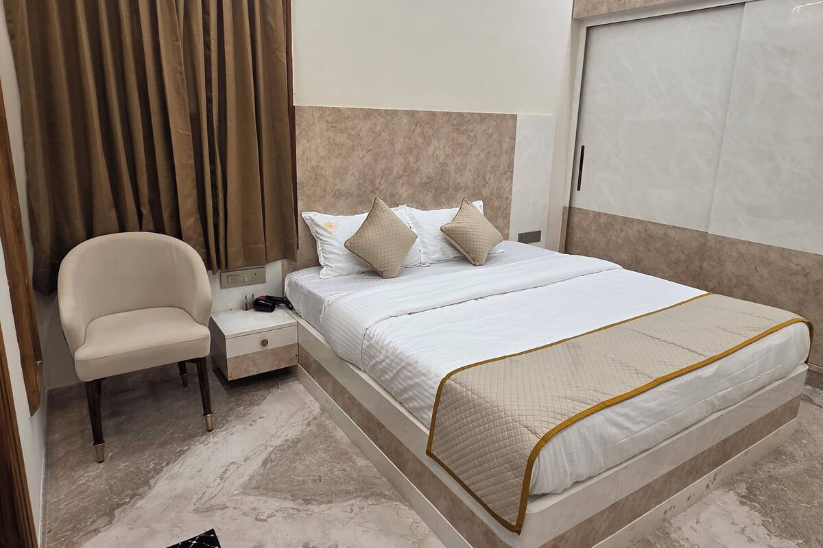 Une chambre d’hôtel comprenant un lit, une chaise, une table de chevet et une armoire.