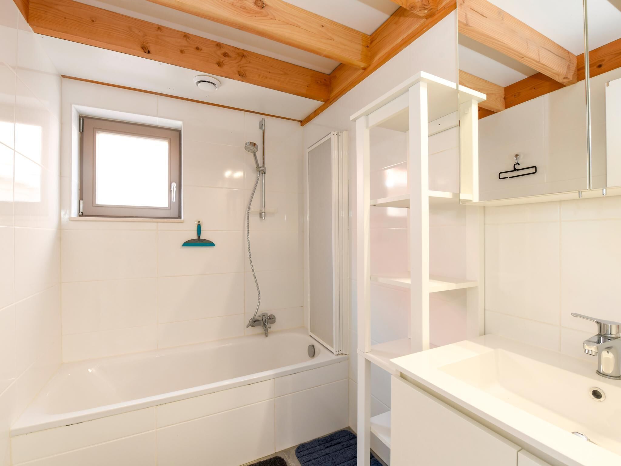 Une salle de bain moderne avec une baignoire, une douche et une fenêtre.