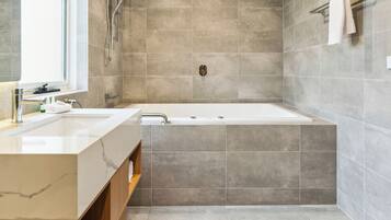 Un baño moderno con una bañera grande, un lavamanos doble y zona de ducha.