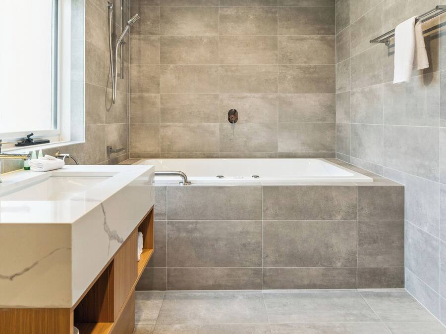 Un baño moderno con una bañera grande, un lavamanos doble y zona de ducha.