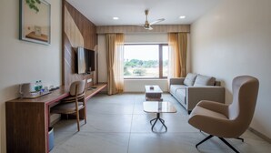 Une chambre moderne équipée d’un bureau, d’une chaise, d’un canapé et d’un ventilateur de plafond.