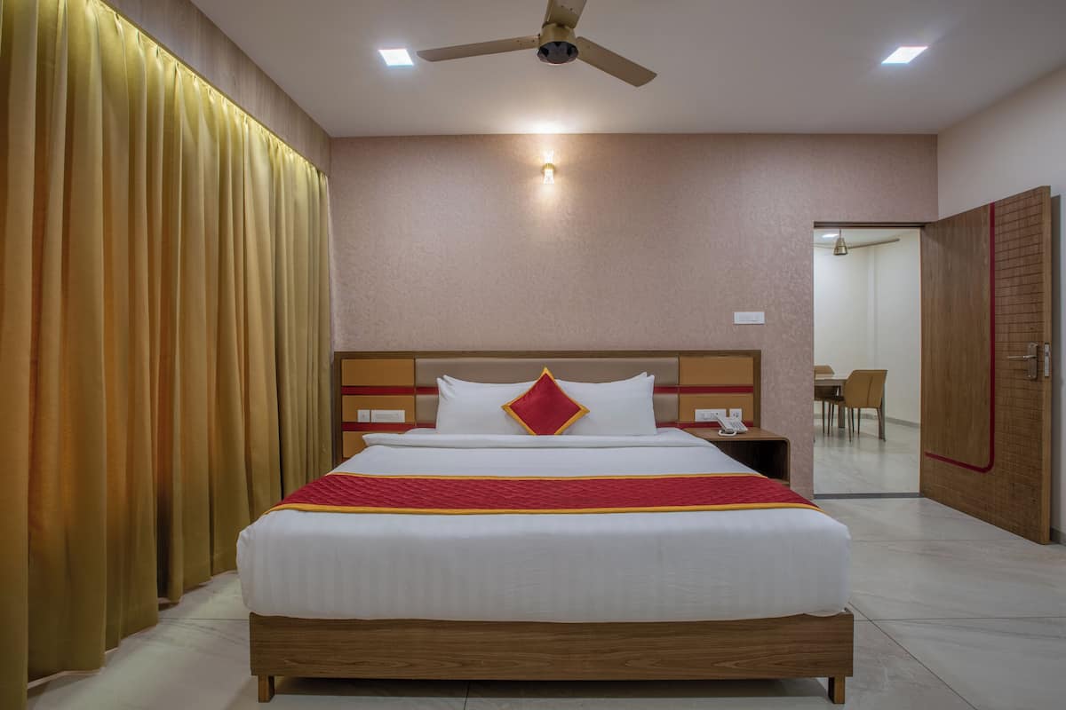 A hotel room with a bed, a ceiling fan, and a nightstand.