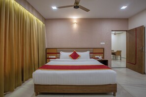A hotel room with a bed, a ceiling fan, and a nightstand. - La Antaraa  (Tiruchendur)