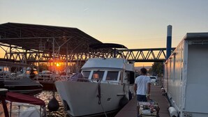 Un quai avec des bateaux, un espace abrité et une personne qui pousse un chariot.