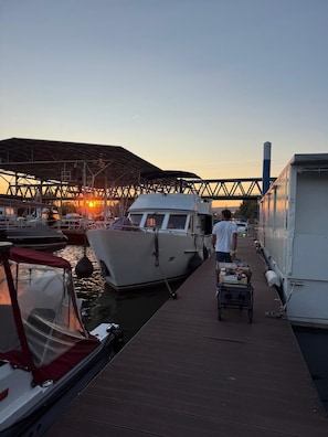A dock with boats, a covered area, and a person with a cart.