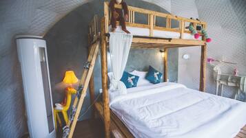 A bunk bed with a monkey plush toy, a lamp, and a small table with a toy.