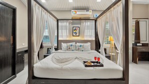 A four-poster bed with a tray of snacks and glasses, a bedside table, a lamp, and a framed picture on the wall. - Alaya Stays Lavender Hills 3BHK Villa (Lonavala)