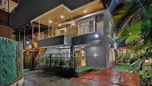 A two-story building with a covered outdoor area, a gated entrance, and a staircase leading to the upper level. - Alaya Stays Lavender Hills 3BHK Villa (Lonavala)