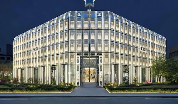 A modern building with a curved facade, large windows, and a prominent entrance.