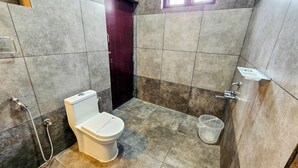 Une salle de bain avec des toilettes, une douche et un lavabo.