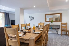 A dining area with a wooden table, chairs, and a mirror on the wall. - Chalet in Paradiski With Spa & Stunning Views (Peisey-Nancroix)