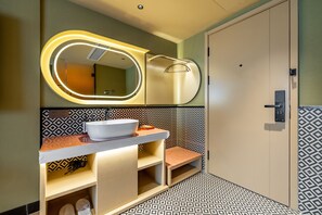Une salle de bain avec un meuble-lavabo, un miroir et un carrelage décoratif.