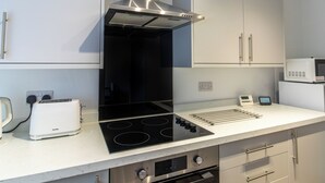 A modern kitchen with a built-in stove, oven, and microwave. - One Bed Apartment in Wellington (Telford and Wrekin)