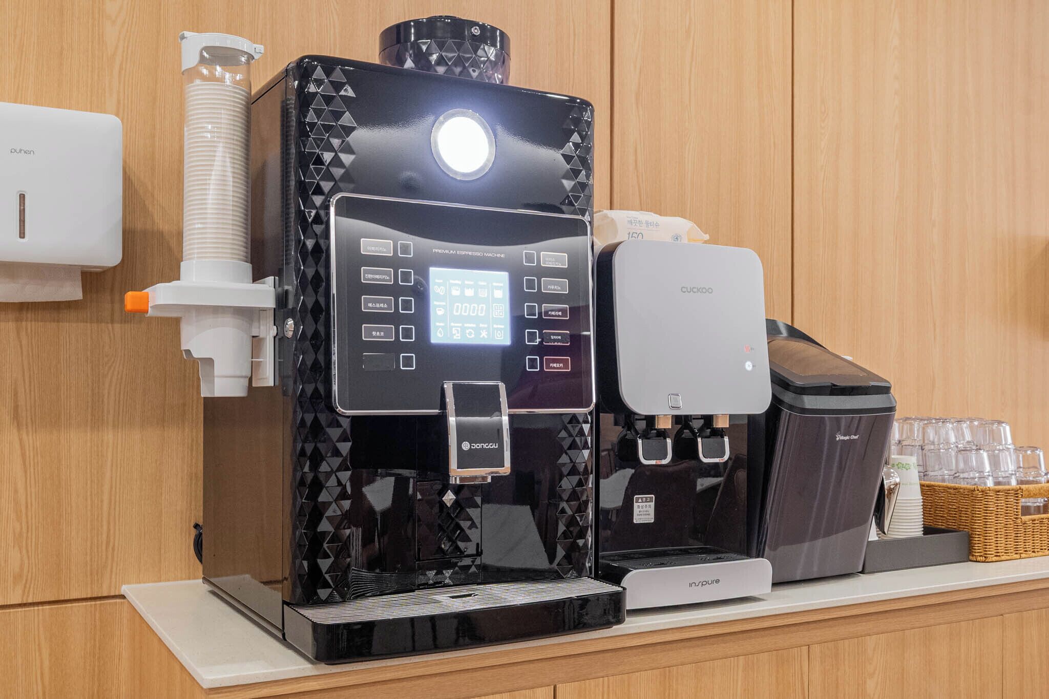 A coffee machine with a digital display, a water dispenser, and a coffee maker on a counter.