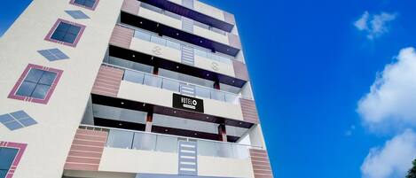 A multi-story hotel with a modern design, featuring balconies and a prominent 'HOTEL' sign.