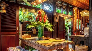 Un intérieur en bois avec une table à manger, des bancs et un sol à motifs.